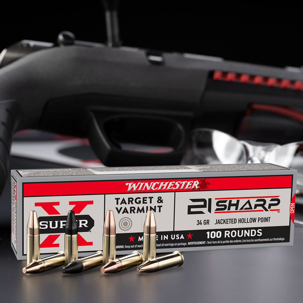 21 Sharp bullet ammo box on a table with rimfire bullets displayed in front and gun behind